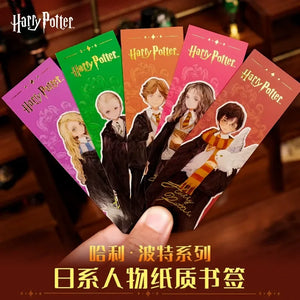 Set of Harry Potter-themed bookmarks held by a hand on a wooden surface.