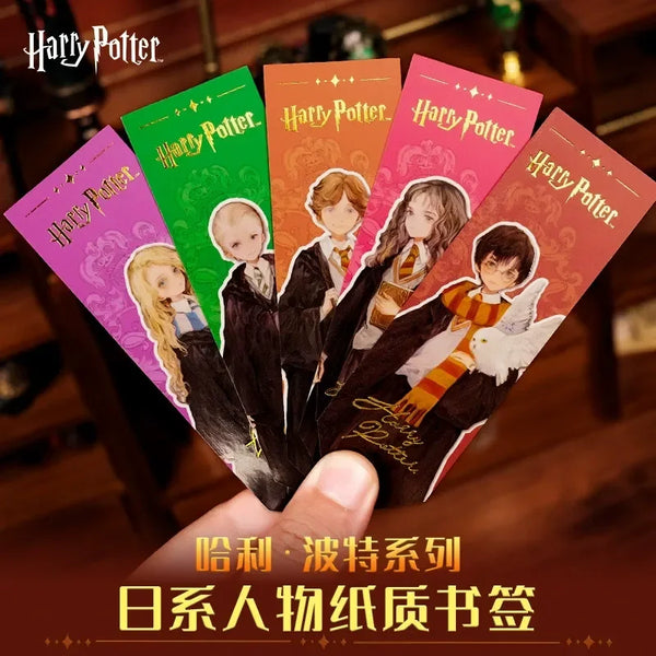 Set of Harry Potter-themed bookmarks held by a hand on a wooden surface.