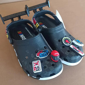 Black clogs with colorful stickers on a brown background