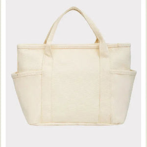 Beige tote bag with 'Peanuts' branding on a light beige background
