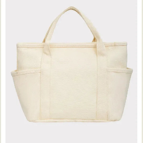 Beige tote bag with 'Peanuts' branding on a light beige background