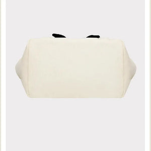 White pouch with black accents on a beige background, featuring the brand 'Peanuts'.