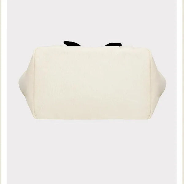 White pouch with black accents on a beige background, featuring the brand 'Peanuts'.