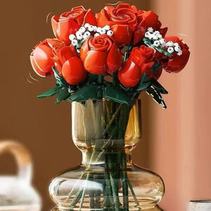 Bouquet of red roses in a clear glass vase on a table with a blurred background