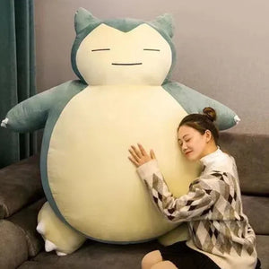 Person hugging a large Snorlax plush toy in a living room setting.