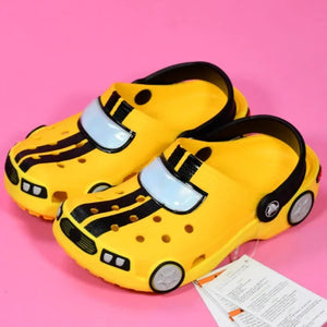 Yellow children's shoes with black stripes on a pink background
