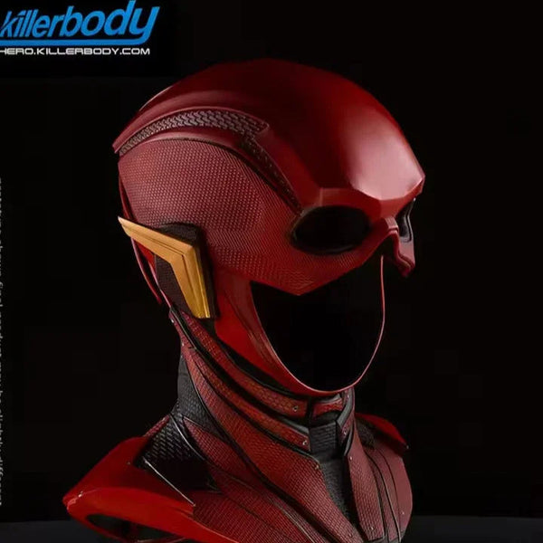 Red superhero helmet with gold accents on a black background, featuring the Justice League logo.